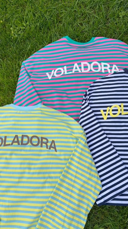 Anuncio de Voladora: tres camisetas de rayas de colores sobre el césped