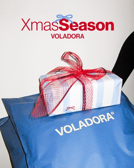 Anuncio de Voladora para Navidad: caja de regalo con lazo rojo sobre una bolsa azul de la marca