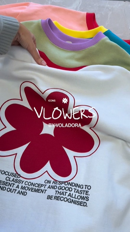 Anuncio de Voladora: sudaderas de colores en el suelo con el detalle del bordado de flor