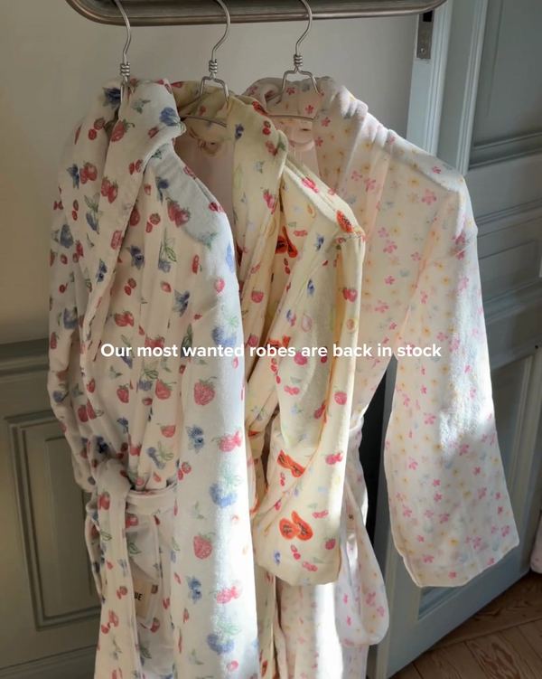 Batas estampadas colgadas en perchas con el aviso de que vuelven a estar disponibles, de Djerf Avenue