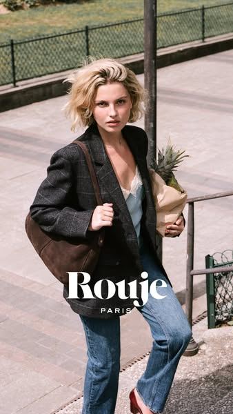 Modelo caminando por la calle con vaqueros, chaqueta y bolso, campaña de Rouje